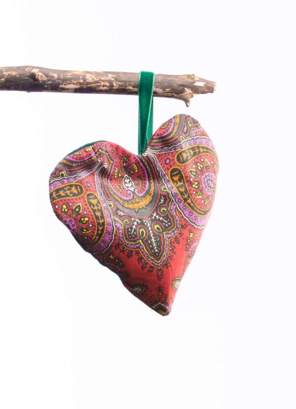 LoullyMakes Xmas produts 71 scaled e1612642929179 Gorgeous hanging heart-shaped herb pillow, lovingly handmade in our own exclusive John Muir Way tartan. These scented sachets are backed with a beautiful Liberty Art Fabric and finished with a velvet ribbon loop and decorative button - so can be hung from coat hangers, drawer handles, bedsteads , coat hooks, Christmas Trees, anywhere you like really. Each heart is filled with my own recipe of dried lavender , chamomile and hops - a combination which acts as a relaxing fragrance in the home. Enliven the scent occasionally by shaking the mix inside the heart, or place near a warm radiator for a fragrance boost . If hung near wardrobes, closets or drawers, this scented herb mix will also keep moths away from your favourite linens and garments ! NB DO NOT PLACE NEAR ANY NAKED FLAME OR DIRECT HEAT SOURCE. All tartans are 100% wool kiltweight woven tartans. Each tartan heart will be backed with a co-ordinating printed tana lawn cotton, which may vary from that pictured.