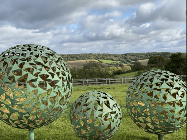 IMG 4377.HEIC Trio of Sphere Sculpture Our NEW Trio of Sphere Sculpture, three different size spheres arranged in a triangular layout, these spheres together can create that huge wow factor to your outdoor or indoor space. Our spheres are also available individually, please see our shop. We are able to offer all our sphere styles & finishes in this trio of sphere sculpture.   This selection of spheres displayed here are our Verdigris & Gold 1.5m, 1m & 65cm - Prices may vary, dependant on the sizes you choose, also styles and finishes can affect costs.   *Additional Charges for Installation, Delivery & Illumination Kits Available On Request.   Our Verdigris & Gold Spheres Handmade in Buckinghamshire Designed and Handcrafted by Elliott of London from mild steel with a luxurious progressive Verdigris Aged Bronze Exterior and glowing Gold gilt Interior. This piece is hot zinc galvanised initially to secure and protect the piece from nature and rust for over 30 years. "Each sail piece individually textured and finished with a luxurious patina by hand!" Designer Charles. Inspired by nature, with weather aged Patina on the outside with new bright gold on the inside.It can be used as a garden vocal point or also as an interior piece, it can be scaled down accordingly and illuminated internally. Available floating above ground level or raised on a choice of stone plinths. Illumination Kits available. Alternative sizes and alternative finished plinths are available at additional costing - please call for more information.   All Enquiries Welcome Worldwide Shipping & Installation Available   We Welcome Studio Visits - By Appointment Only www.elliottoflondon.co.uk info@elliottoflondon.co.uk 01494 758 896