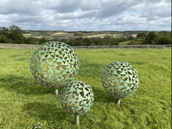 IMG 4384.HEIC Trio of Sphere Sculpture Our NEW Trio of Sphere Sculpture, three different size spheres arranged in a triangular layout, these spheres together can create that huge wow factor to your outdoor or indoor space. Our spheres are also available individually, please see our shop. We are able to offer all our sphere styles & finishes in this trio of sphere sculpture.   This selection of spheres displayed here are our Verdigris & Gold 1.5m, 1m & 65cm - Prices may vary, dependant on the sizes you choose, also styles and finishes can affect costs.   *Additional Charges for Installation, Delivery & Illumination Kits Available On Request.   Our Verdigris & Gold Spheres Handmade in Buckinghamshire Designed and Handcrafted by Elliott of London from mild steel with a luxurious progressive Verdigris Aged Bronze Exterior and glowing Gold gilt Interior. This piece is hot zinc galvanised initially to secure and protect the piece from nature and rust for over 30 years. "Each sail piece individually textured and finished with a luxurious patina by hand!" Designer Charles. Inspired by nature, with weather aged Patina on the outside with new bright gold on the inside.It can be used as a garden vocal point or also as an interior piece, it can be scaled down accordingly and illuminated internally. Available floating above ground level or raised on a choice of stone plinths. Illumination Kits available. Alternative sizes and alternative finished plinths are available at additional costing - please call for more information.   All Enquiries Welcome Worldwide Shipping & Installation Available   We Welcome Studio Visits - By Appointment Only www.elliottoflondon.co.uk info@elliottoflondon.co.uk 01494 758 896