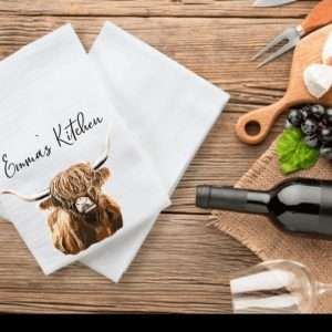 Highland cow illustration on a tea towel, personalised with name of your choice in a decorative font.