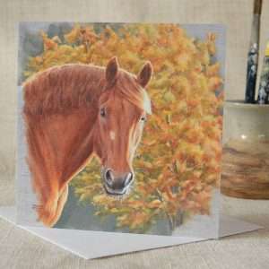 Suffolk Punch horse art head study square blank greetings or birthday card. Viewed upright on top of a white envelope with small vase containing paintbrushes in the background