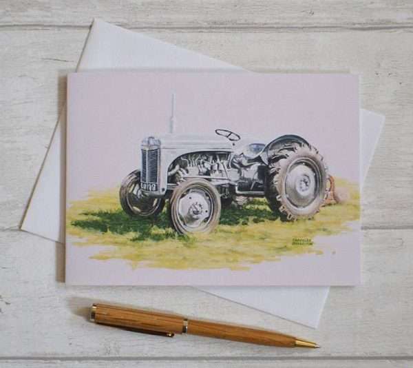 Grey Ferguson tractor art on a blank, oblong birthday card. Viewed flat from above on top of white envelope with pen in foreground for scale