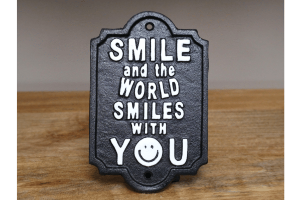 smile Our Cast Iron "Smile and the World Smiles with You" Sign is a beautiful reminder of the power of positivity. Crafted with meticulous attention to detail, this sign is more than just a decorative piece; it's an embodiment of an uplifting mantra that has the potential to brighten your day and those around you.